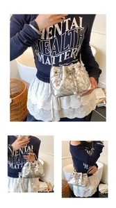 Detail of silver quilted bucket bag featuring rhinestones and pearl drawstring tassels