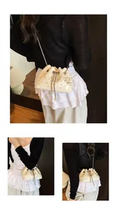 Detail of quilted bucket bag featuring rhinestone accents and elegant pearl chain tassels