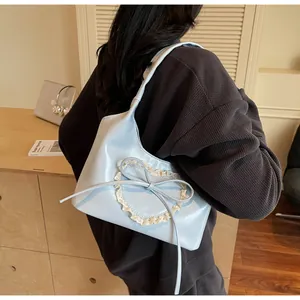 Dettaglio della borsa azzurra con cuore di pizzo e decorazione a fiocco