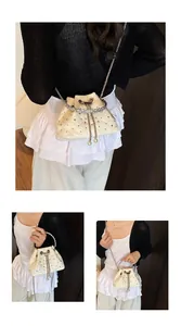 Detail of cream quilted bucket bag featuring rhinestone accents and pearl drawstring charms