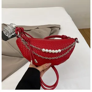 Dettaglio della borsa a mezzaluna intrecciata rossa con catena e cinque perle