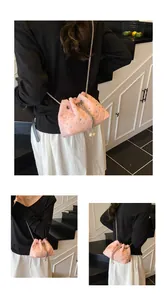 Detailed view of pink quilted bucket bag with pearl drawstring and metal chain strap