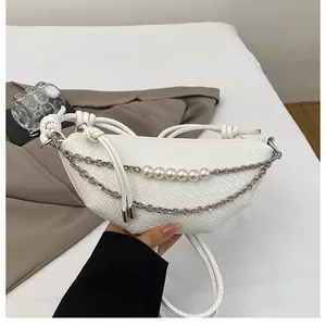 Dettaglio della borsa in PU intrecciato bianco con catena argento e decorazione di perle