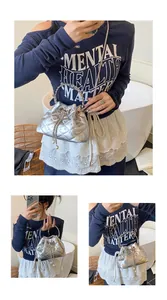 Detail view of silver quilted bucket bag with pearl drawstring and metal chain strap