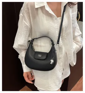 Dettaglio della borsa hobo nera a grana litchi con cerniera argentata e logo in metallo