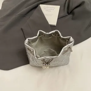 Silver quilted drawstring bucket bag with sparkling rhinestones and pearl chain accents