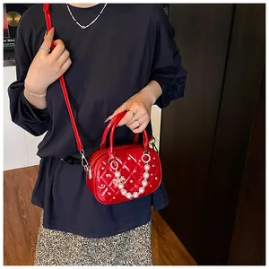 Detail of red quilted bowling bag with sparkling rhinestones and a pearl bow charm