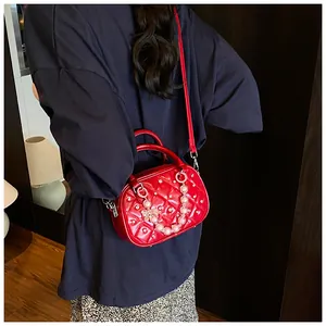 Detailed view of red quilted patent leather bowling bag with pearl chain and sequins