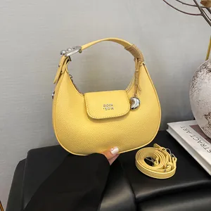 Borsa hobo giallo pallido con trama litchi e manico annodato con ciondolo a cuore