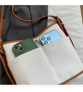Close-up of canvas bucket bag with dual front pockets for smartphone storage