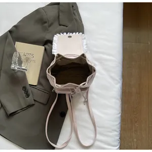Détail de l'intérieur du sac à dos rose clair avec cordon et bordure en dentelle
