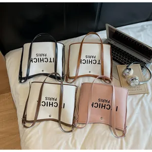 Detail view of four contrast color PU leather tote bags with letter print and straps