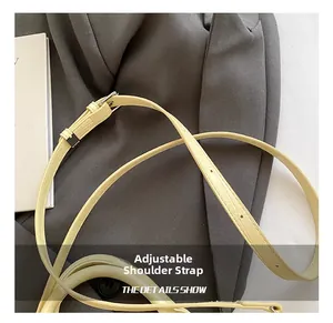 Detail of adjustable light yellow crocodile pattern strap with silver metal buckle