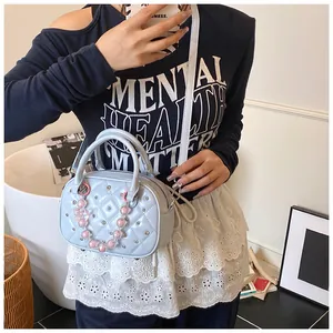 Detail of light blue quilted bowling bag with silver studs and decorative beads