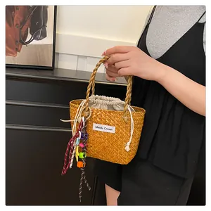 Close-up of woven straw handbag with drawstring lining and colorful bead charms