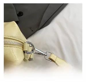 Detail shot of a yellow bowling bag featuring faux crocodile skin texture and silver hardware