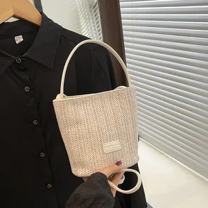 Borsa a secchiello in paglia intrecciata beige con texture a contrasto e tracolla