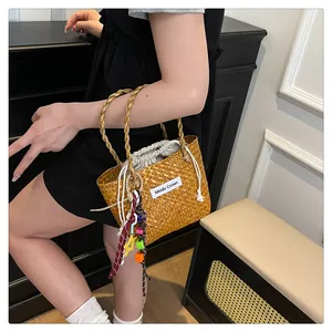 Detail of hand-woven straw tote bag with drawstring lining and decorative star pendant
