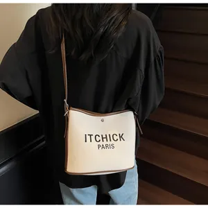 Outdoor shot of the canvas bucket bag showing leather strap and contrast stitching details