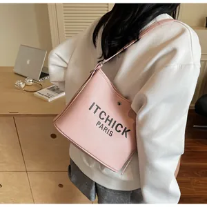 Detail of pink canvas bucket bag with black ITCHICK letter print and leather strap