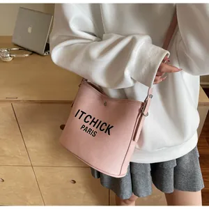Detail of pink leather crossbody bag with black ITCHICK PARIS logo and textured surface
