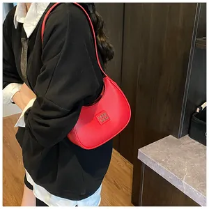 Close-up of red lychee pattern leather hobo bag featuring a square metal logo on shoulder