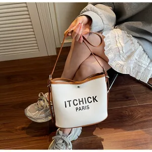 Detailed shot of canvas bucket bag with leather trim and ITCHICK PARIS logo on front