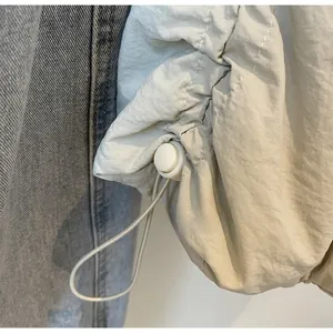 Dettaglio dell'orlo con coulisse regolabile e fermo in plastica sulla borsa in nylon