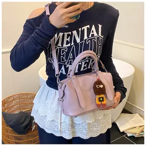 Detailed view of light purple crocodile pattern bowling bag with cute doll charm strap