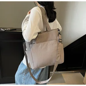 Dettaglio della borsa tote in tela kaki con tracolla regolabile e tasche laterali