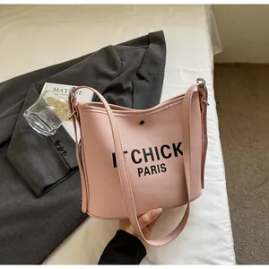 Detail of pink canvas bucket bag with magnetic clasp closure and leather trim detailing