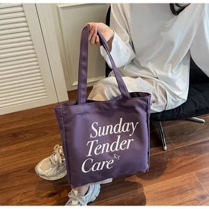 Dettaglio della borsa tote in tela viola con scritte artistiche bianche Sunday Tender Care