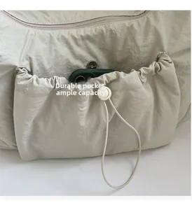Dettaglio tasca laterale con coulisse della borsa a tracolla in nylon con telefono