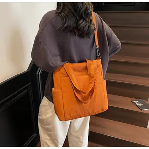 Dettaglio della borsa tote in nylon arancione con tasche funzionali e tracolla nera