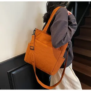 Dettaglio della borsa tote in nylon caramello con tracolla regolabile e tasca laterale