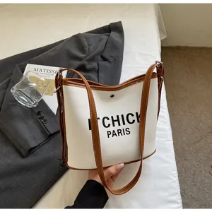 Top view of canvas bucket bag with leather trim and Chick Paris letter print detail