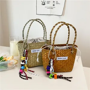 Woven straw handbag in green and tan with drawstring lining and colorful NICE charm