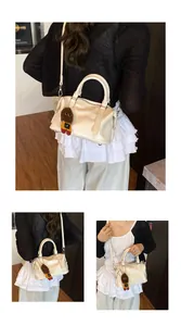 Detail of cream bowling bag with crocodile texture and a cute plush doll charm