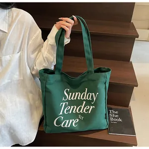 Dettaglio della borsa tote in tela verde scuro con stampa e trama in tessuto di tela spessa