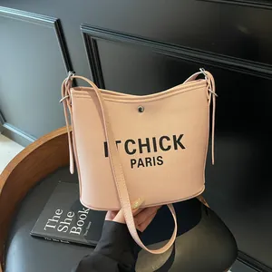 Pink canvas bucket bag with IT CHICK PARIS print and adjustable shoulder strap
