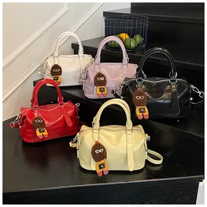 Detail view of five textured crocodile embossed leather bowling bags with doll pendants