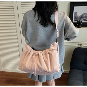 Dettaglio della borsa a tracolla in nylon rosa con coulisse e cinturino regolabile ampio