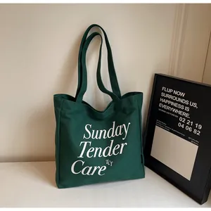 Dettaglio della borsa tote in tela verde scuro con stampa di lettere Sunday Tender