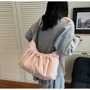 Dettaglio della borsa a tracolla in nylon plissettato rosa chiaro con chiusura a coulisse