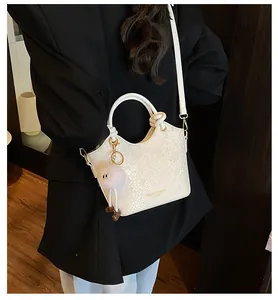 Détails du sac à main en serpent crème avec pendentif en peluche et bandoulière chic