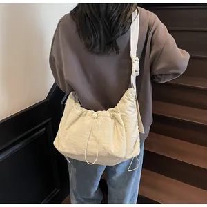 Dettaglio della borsa hobo beige in nylon con chiusura a coulisse e fibbia regolabile