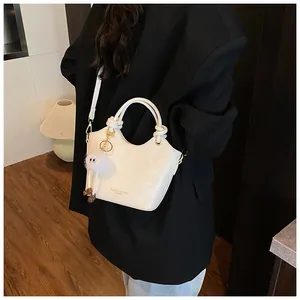 Détail du sac à main blanc à motif serpent avec texte de mode et pendentif en fourrure