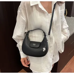 Dettaglio della borsa hobo in pelle nera martellata con ciondolo a cuore e tracolla