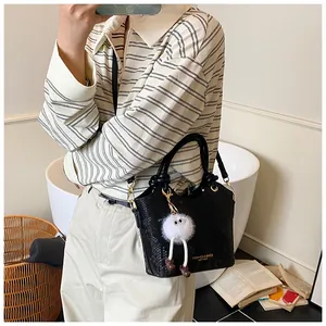 Détail du sac à main noir motif serpent avec texte doré et un joli pendentif en peluche