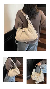 Dettaglio della borsa a tracolla in nylon beige con texture pieghettata e fibbia